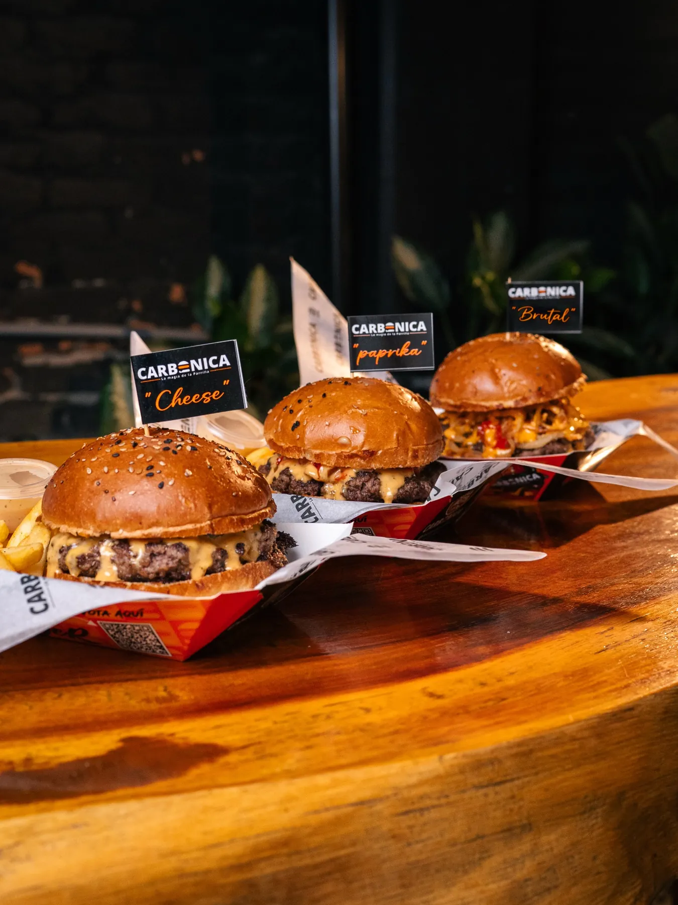Cheese Burger, Paprika Burger y Brutal Burger de Carbónica servidas juntas sobre la mesa